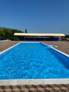 Kryve OzeroHotel Kryve Ozero的一座蓝色的大型游泳池,其建筑背景为: