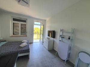 苏曼婷Villa Adagio Apartments的客房设有一张床和一间带电视的浴室。