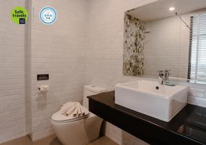 清迈the echo hotel的白色的浴室设有水槽和卫生间。