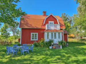 SläthultLunden的院子里的红色房子,配有桌椅
