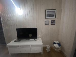 乌斯特卡Domek Morze的客房内的白色橱柜里配有电视