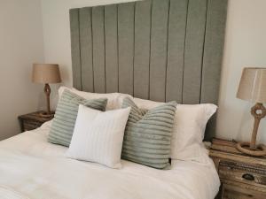 伯翰姆昂斯Seashell luxury apartment的一张带绿色床头板和白色枕头的床