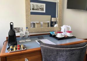 浦耳Haven Hotel的一张位于酒店客房内的桌子,配有电话和镜子