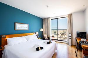 瓦伦西亚Hotel Valencia Oceanic Affiliated by Meliá的配有一张床、一张书桌和一扇窗户的酒店客房