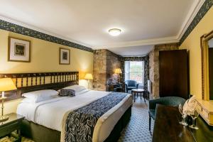 邦尼里格达尔豪西城堡酒店 的配有一张床和一张书桌的酒店客房