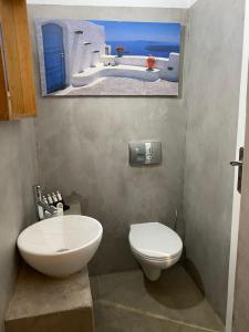科里夏AEGEAN VIEW SEASIDE ROOMS AND STUDIOS KEA的一间带卫生间的浴室和墙上的照片