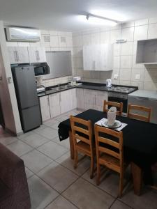 圣卢西亚Villa Mia 15的厨房配有桌椅和冰箱。