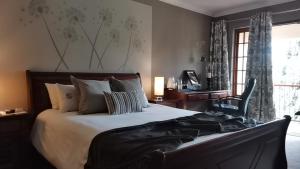 约翰内斯堡2扇门旅馆的一间卧室配有一张床、一张书桌和一个窗户。