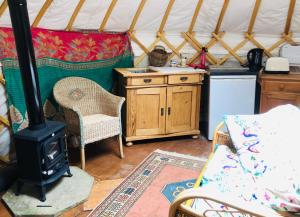 斯托尔河畔希普斯顿Cotswolds Camping at Holycombe的蒙古包内带炉灶的房间
