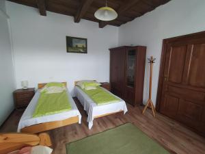 VadnaHeni Vendégháza的一间卧室设有两张床,铺有木地板