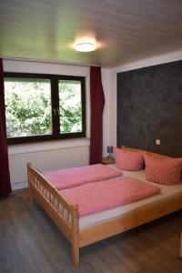 维林根Hotel Engelbracht inklusive MeineCardPlus的一间卧室配有一张带红色枕头的大床