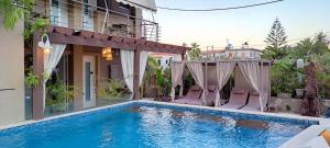 Loutrópolis Thermís加拉基奥阿斯特里伊酒店的一个带两把椅子的游泳池以及一座房子