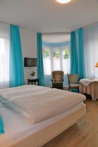 巴登韦勒马克格拉弗勒酒店的一间卧室配有一张带蓝色窗帘的大床