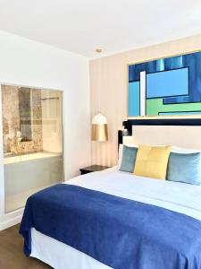 华沙Luxury Apartments MONDRIAN Market Square III的卧室配有蓝色和白色的床和窗户。