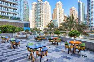 迪拜Crowne Plaza Dubai Marina, an IHG Hotel的一个带桌椅的庭院和建筑
