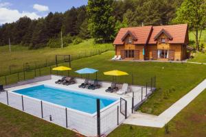 Donji Babin PotokPlaninske kuce Good Night的享有带遮阳伞和房屋的游泳池的顶部景致