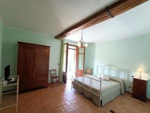 MurisengoLa Ca Veja的一间卧室配有一张床和一张书桌及电视