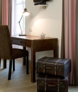 坦嫩基什Hôtel du Haut Koenigsbourg- entre vignes et château的一张桌子、椅子、一张桌子和行李箱