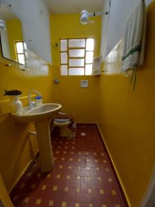 圣保罗Infinito House - Casa inteira的黄色的浴室设有水槽和卫生间