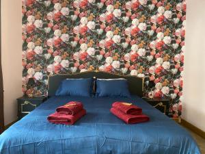 那慕尔The Pink Studio - Exceptional location IN city center - Unique & Elegant的一张带两个红色枕头的床和花卉墙