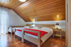 Ljubno卢布诺赛文吉派维克客房及旅舍的一间卧室设有两张床和木制天花板