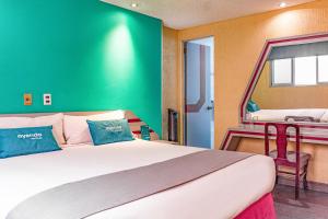 墨西哥城Ayenda Frida Costa Azul的一间卧室设有一张大床和绿色的墙壁
