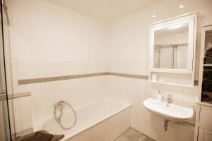锡格堡bonquartier - groß & stylisch - zentral & komfortabel的白色的浴室设有水槽和浴缸。