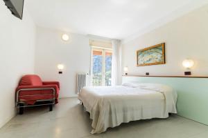 德罗Aktiv Hotel Eden的白色卧室,配有床和红色椅子