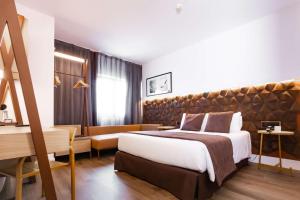 巴塞罗那阿尔法机场贝斯特韦斯特PLUS酒店的酒店客房设有一张大床和一张书桌。
