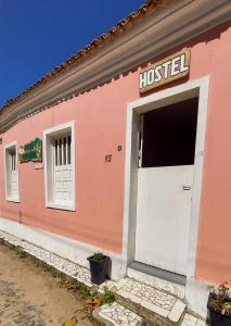 普拉杜Hostel Casa Grande的粉红色的房子,有白色的门