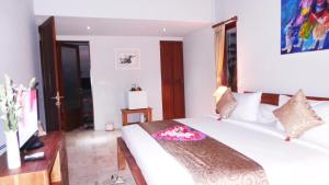 德格拉朗哥文宁别墅酒店的卧室配有白色的床和电视。