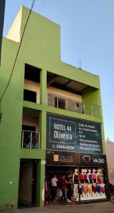 戈亚尼亚Hotel Oliveira 44的前面有标志的绿色建筑