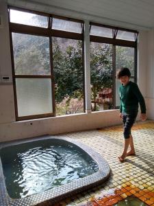 仙台ペット可 Akiu-Canada 鴻ノ巣温泉的站在游泳池前的一个男孩