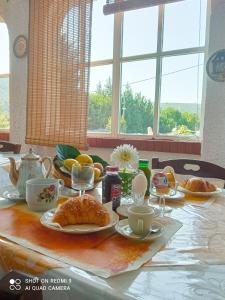 SorianelloB&B PASSO DEL FALCO的一张桌子,上面有羊角面包和橙子的早餐