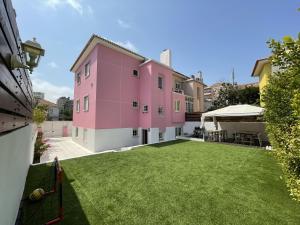 里斯本SK Lisboa Villa Guesthouse的粉红色的房子,有大院子