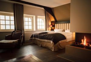 奥斯纳布吕克罗曼蒂克瓦哈拉酒店的酒店客房配有一张床和一个壁炉。