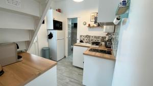 勒克罗图瓦Le 5 en baie, maison pour 4 personnes的厨房配有白色橱柜和白色冰箱。