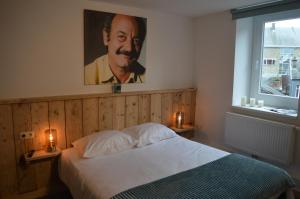 斯帕Luxury Spa Hotel - Francofolies的卧室配有一张带人像的床
