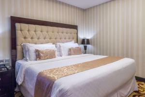 泗水泗水温德姆酒店的一间卧室配有一张大床和一张白色的大床罩