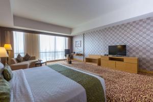 泗水泗水温德姆酒店的配有一张床和一台平面电视的酒店客房