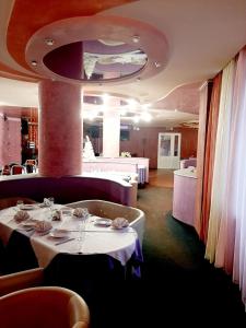 维捷布斯克Hotel Vetraz的一间用餐室,配有2张带白色桌布的桌子