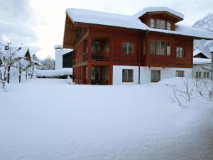 加尔米施-帕滕基兴Gapartments的雪中的房子,有雪覆盖的院子