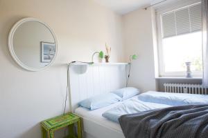 威克奥夫弗尔Oland Whg 14 Nordseetraum的一间卧室配有镜子和一张带蓝色枕头的床