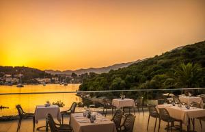 科尔丘拉Aminess Port 9 Resort的餐厅设有桌椅,享有日落美景。