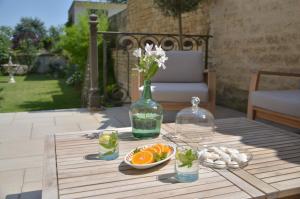 尼奥尔Chambres d'hôtes - La Maison 19的花瓶和一碗橙子的桌子