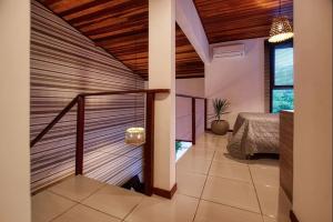 皮帕APARTAMENTO 2 QUARTOS EQUIPADO NO BOSQUE DA PRAIA FLATS - PIPA NATUREZA的一间设有楼梯的房间,位于一栋带床的房子里