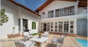 拉罗马纳Lux Villa Casa de Campo的房屋设有带椅子和桌子的庭院