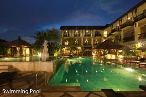 勒吉安The Lokha Legian Resort & Spa的夜间在酒店前的游泳池