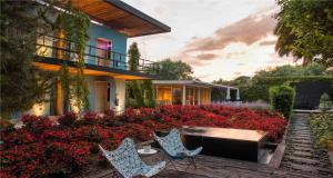 圣克里斯托瓦尔-德拉斯卡萨斯博酒店的一座带红色鲜花的花园的房子