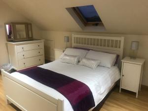 邓甘嫩Tranquil Modern Countryside Bungalow的卧室配有一张白色大床和电视。